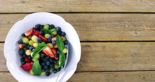 Fresh Berry and Grape Salad in White Bowl on Wooden Table - Download Free Stock Images Pikwizard.com