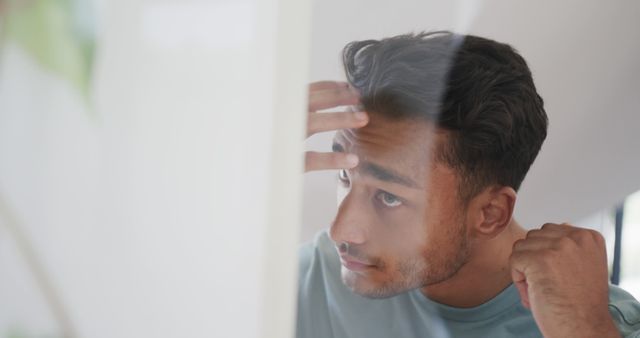 Young Man Perfecting Hairstyle with Grooming Routine - Download Free Stock Images Pikwizard.com