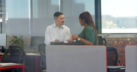 Colleagues engaging in empowering office discussion with tablet