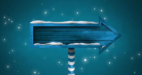 Blue wooden arrow with snow on festive background