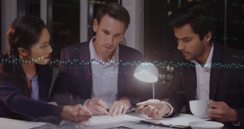 Diverse Business Team Analyzing Data Together at Night