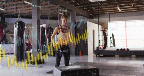 Female athlete preparing plyo box jump in industrial gym with fitness data visualization