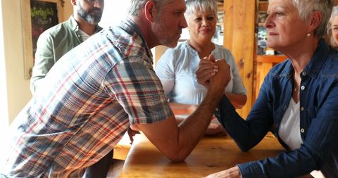 Friendly Arm Wrestling Competition Among Middle-Aged Friends - Download Free Stock Images Pikwizard.com