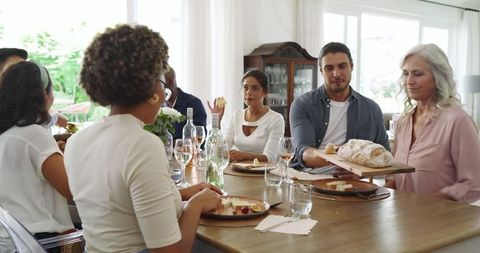 Family and Friends Enjoying Meal Together in Bright Dining Room