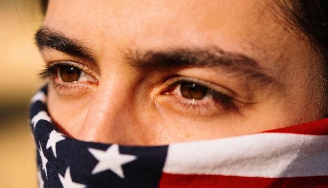 Closeup portrait of man wearing american flag bandana showing brown eyes at golden hour