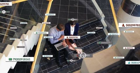 Business colleagues collaborating on laptop and tablet with digital ui overlays on stairs