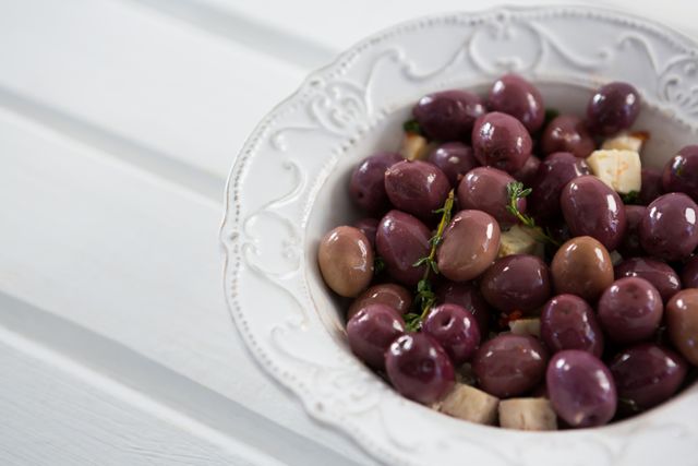 Close-up of marinated olives with herbs in a bowl on table