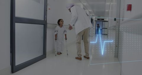 Caring Doctor Engaging with Young Patient Using Crutches in Hospital