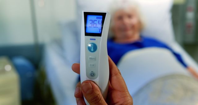 Close up of thermometer holding held by surgeon with Caucasian patient on bed on background at hospital 4k