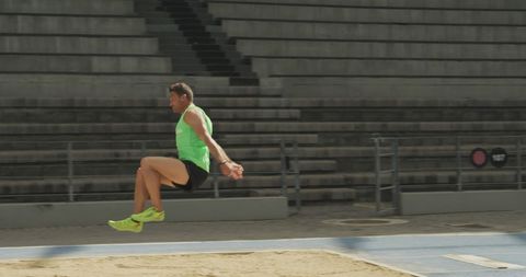 Athlete shows long jump skills in empty stadium
