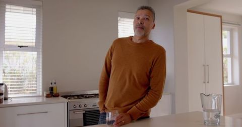 Senior Man Reflecting with Morning Coffee in Bright Modern Kitchen