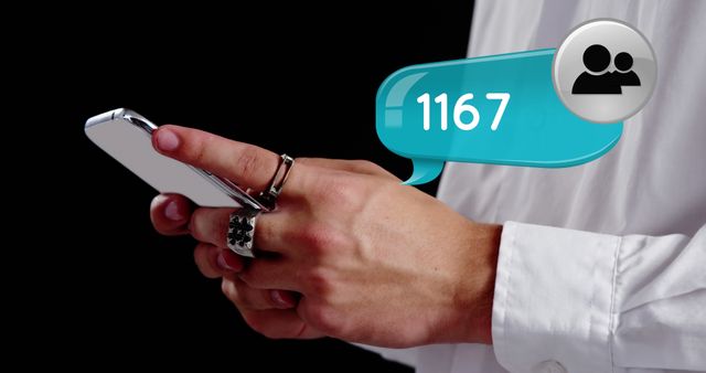 This image shows a person checking social media notifications on a smartphone, indicated by a message bubble showing '1167'. The person wears rings and sleeves of a white shirt are visible against a dark background. This can be used in articles or advertising focused on social media engagement, technology use, communication, or digital culture.