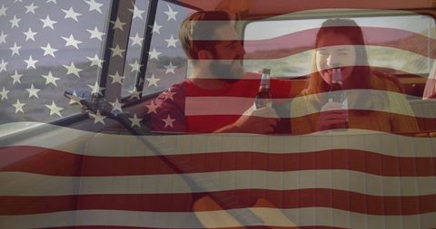 Couple Enjoying Drink in Camper Overlaid with American Flag