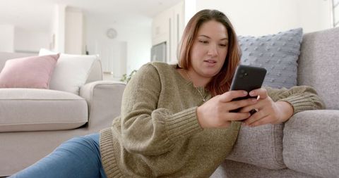 Content Woman Lounging in Cozy Living Room Browsing Smartphone