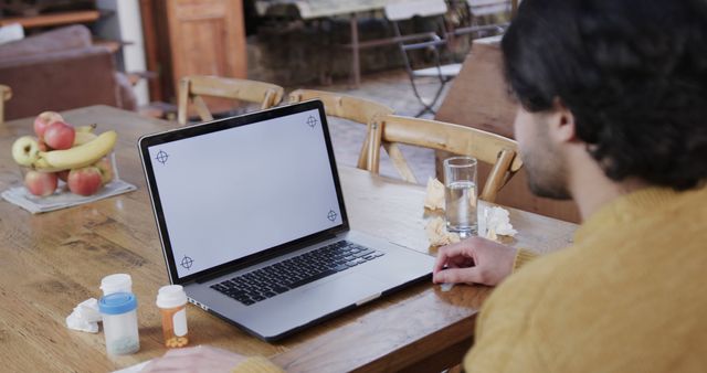 Man Working on Laptop with Prescription Medications on Table at Home - Download Free Stock Images Pikwizard.com