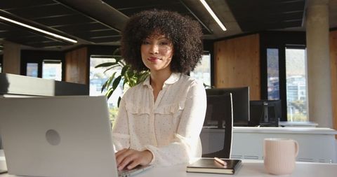 African American Woman Working at Modern Office Desk with Laptop