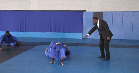 Grappling Training Guided by Instructor in Martial Arts Dojo