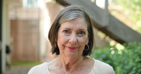 Elegant Senior Woman Smiling in Tranquil Garden