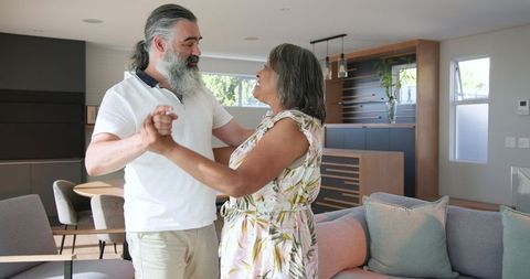 Senior Couple Laughing and Embracing in Modern Living Room