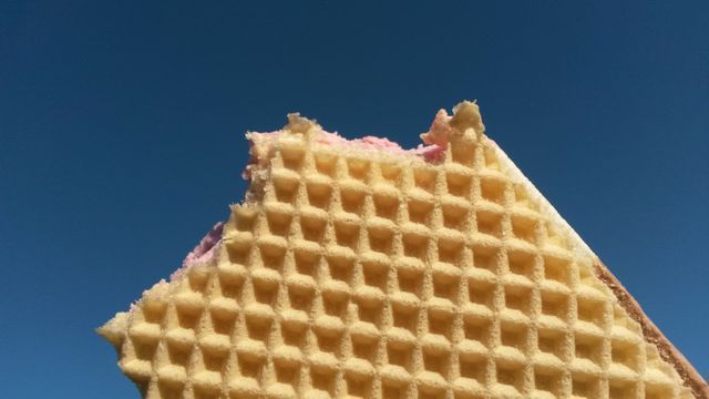 Close-up of Waffle with Bite Missing Against Clear Blue Sky - Download Free Stock Photos Pikwizard.com