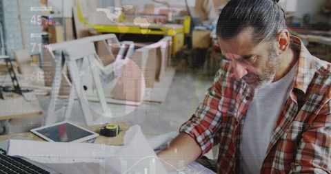 Carpenter Analyzing Data in Workshop with Digital Interface Overlay