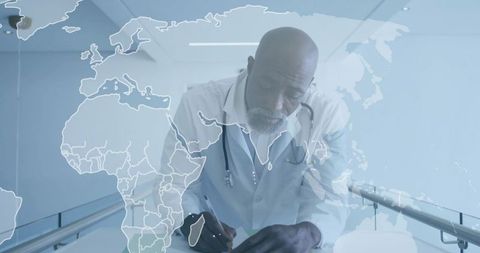 Male doctor leaning over clipboard in modern hospital corridor with global map overlay