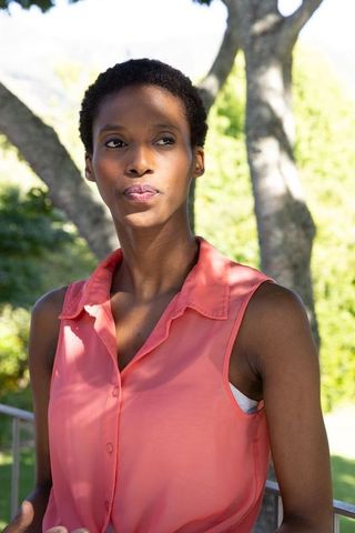 Elegant woman pondering in sunlit outdoor setting