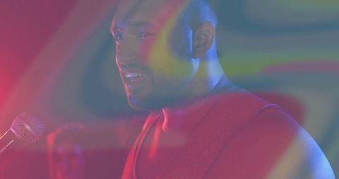 Energetic musician performing on stage with vibrant lighting