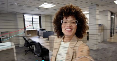 Smiling professional taking selfie in modern open-plan office with data overlay
