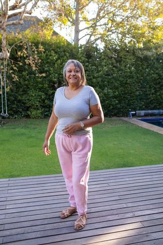 Senior Woman Enjoying Leisure Time on Deck Near Pool