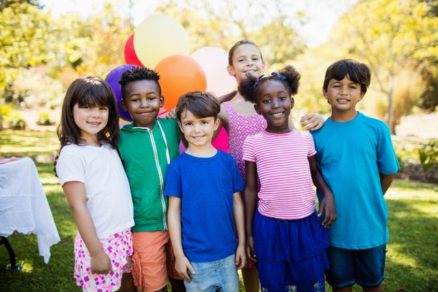 Cute children standing and posing during a birthday party on a park