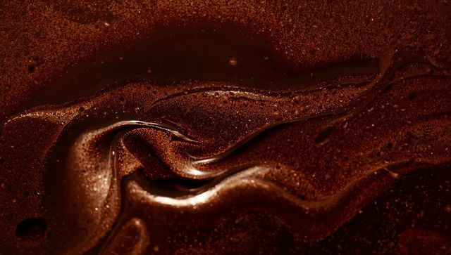 Silky melted dark chocolate swirl with glossy ganache texture and cocoa granules