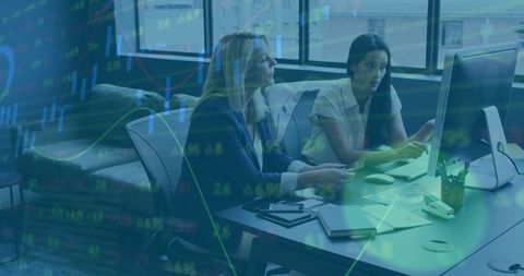 Professional Women Collaborating on Financial Reports in Modern Office