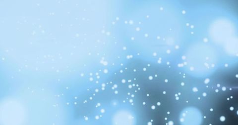 Soft blue bokeh particles floating over gentle gradient for winter, tech, wellness design