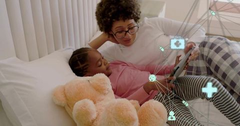 Reading together at bedtime using tablet with augmented health icons for family care