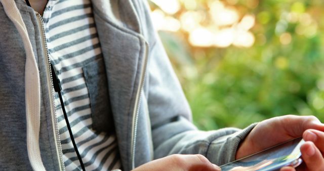 Teen Holding Smartphone Using Headphones Outdoors - Download Free Stock Images Pikwizard.com