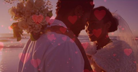 Black Couple Embracing in Romantic Beach Wedding at Sunset