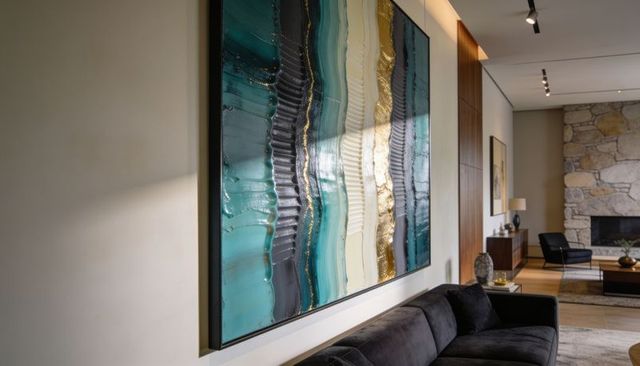 Oversized teal and gold abstract wall art anchoring modern living room with charcoal sofa