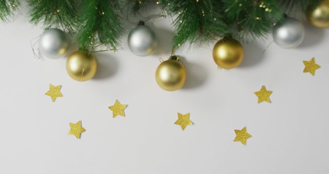 Image of christmas decorations with gold baubles and stars with copy space on white background. christmas, tradition and celebration concept.
