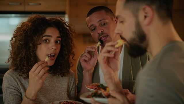 Friends sharing chips and salsa while enjoying casual kitchen gathering and appetizers