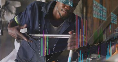 Technician tightening pipe with wrench while augmented reality data overlays workshop