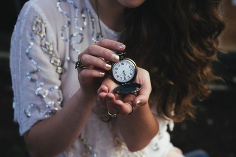 Woman holding vintage pocket watch with elegant nails