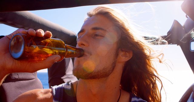 Young Man Drinking Beer on Sunny Road Trip - Download Free Stock Images Pikwizard.com