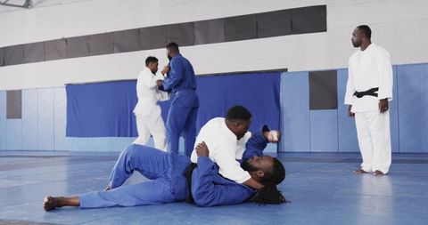 Group of Men Practicing Grappling Techniques in Dojo