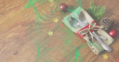 Festive Cutlery Wrapped in Napkin with Plaid Ribbon, Pinecone and Baubles for Holiday Table