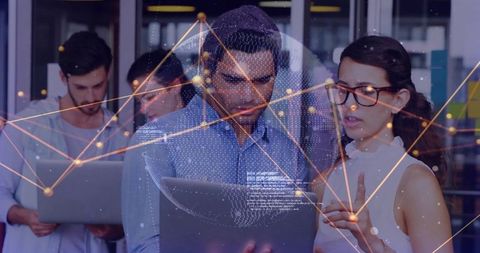 Tech team collaborating and analyzing network overlay on laptop for data visualization