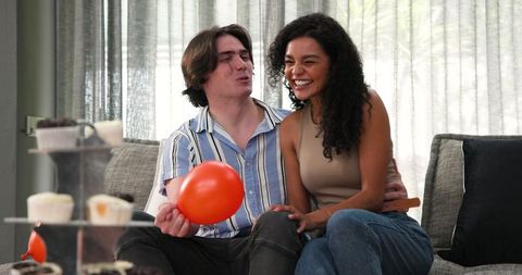 Happy Couple Preparing for Birthday Celebration in Living Room