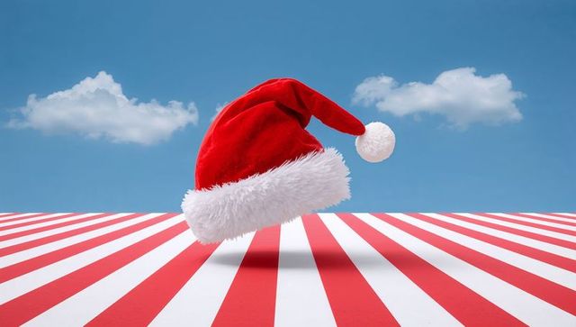 Floating santa hat above red white striped floor with soft shadow and cloudy blue sky