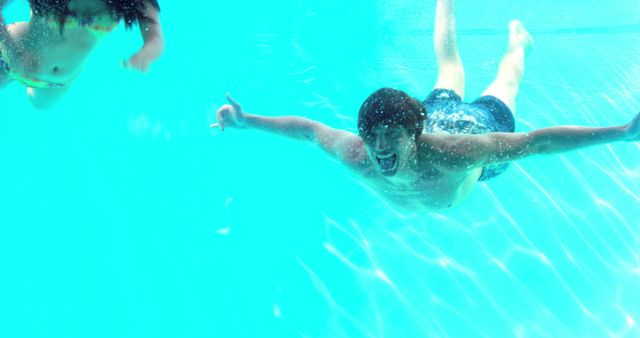 Underwater Fun: Friends Swimming and Diving in Clear Pool - Download Free Stock Images Pikwizard.com