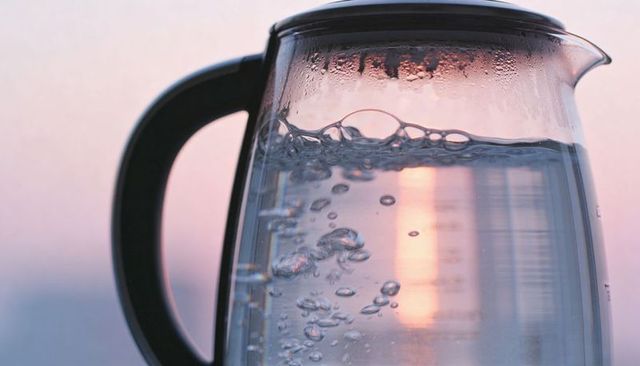 Glass electric kettle boiling sunrise water bubbles warm pastel backlit kitchen glow